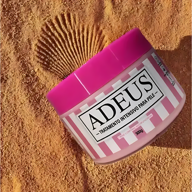 Adeus Cream cellulite and stretch mark cream in a pink and white striped jar on sandy beach background