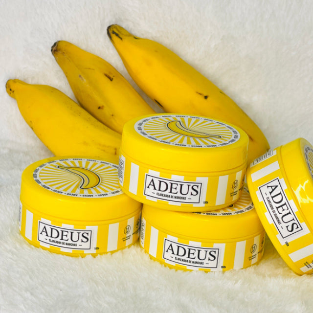 Adeus Dark Spot Correcting Cream for Intimate Areas and Body – 3.52 oz (100g). Product tube displayed with fresh bananas, highlighting natural banana extract for brightening – Buy now at MKPBR.COM – Worldwide Shipping