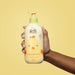 Adult hands holding a dose of O Boticário Boti Baby Gentle Baby Conditioner before applying it to a baby's hair during bath time – Buy now at MKPBR.COM – Worldwide Shipping