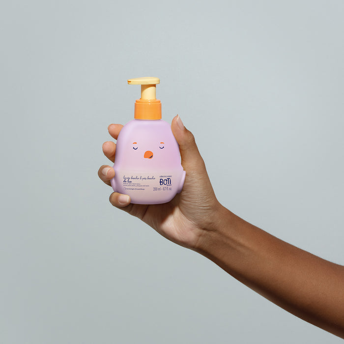 Boticário Boti Baby Lua Bath & After-Bath Baby Lotion pump bottle held in one hand, showing the compact 200 ml size and easy one-handed pump – Buy now at MKPBR.COM – Worldwide Shipping