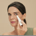 Woman applying Boticário Botik Peptídeos Pró-Elastina eye cream to the under-eye contour with the metal massaging applicator tip – Buy now at MKPBR.COM – Worldwide Shipping
