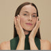 Adult model with hands framing her face showing the eye area cared for with Boticário Botik Peptídeos Pró-Elastina eye cream – Buy now at MKPBR.COM – Worldwide Shipping