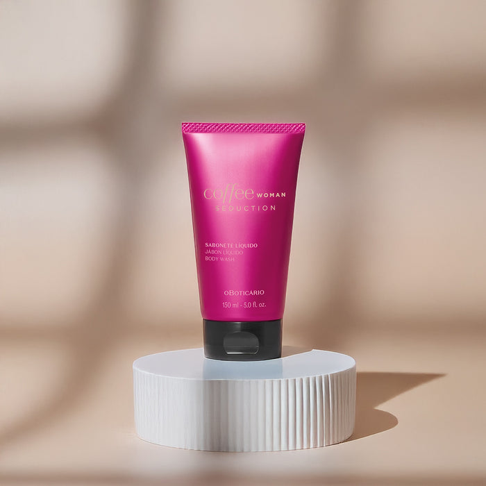 Brazilian O Boticário Coffee Woman Seduction liquid body soap 150 ml tube styled on a white fluted pedestal against a warm beige backdrop – Buy now at MKPBR.COM – Worldwide Shipping