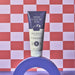 Boticário Cuide-se Bem Boa Noite Brazilian body lotion 200 ml tube standing on a blue arch against a red and lilac checkerboard backdrop – Buy now at MKPBR.COM – Worldwide Shipping