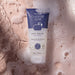 Boticário Boa Noite exfoliating body wash tube surrounded by creamy shower lather and water bubbles – Buy now at MKPBR.COM – Worldwide Shipping