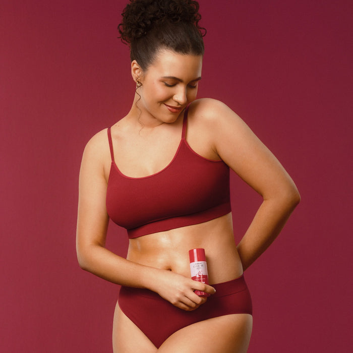 Woman massaging Boticário Cuide-se Bem Cereja de Fases Warming Body Oil over her abdomen for a comforting warm sensation – Buy now at MKPBR.COM – Worldwide Shipping