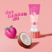 Boticário Doçura na Pessegura razor glide cream on a pink pedestal with 3D peach and coconut props illustrating the smooth gliding shave concept – Buy now at MKPBR.COM – Worldwide Shipping