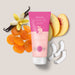 Boticário Doçura na Pessegura shaving cream tube in a flat lay with peach slices, coconut pieces, dried apricot and vanilla, showing the gourmand cocada and peach scent – Buy now at MKPBR.COM – Worldwide Shipping