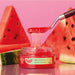 Open jar of Boticário Cuide-se Bem Melancia overnight face mask with pink watermelon gel lifted on a spatula beside fresh watermelon slices – Buy now at MKPBR.COM – Worldwide Shipping