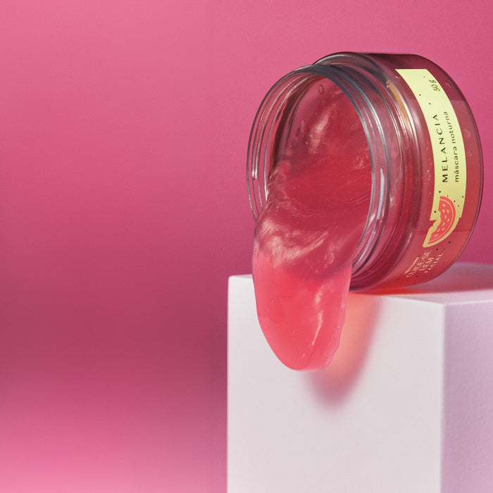 Tilted jar of Boticário Cuide-se Bem Melancia leave-on night mask with pink gel flowing onto a white pedestal – Buy now at MKPBR.COM – Worldwide Shipping