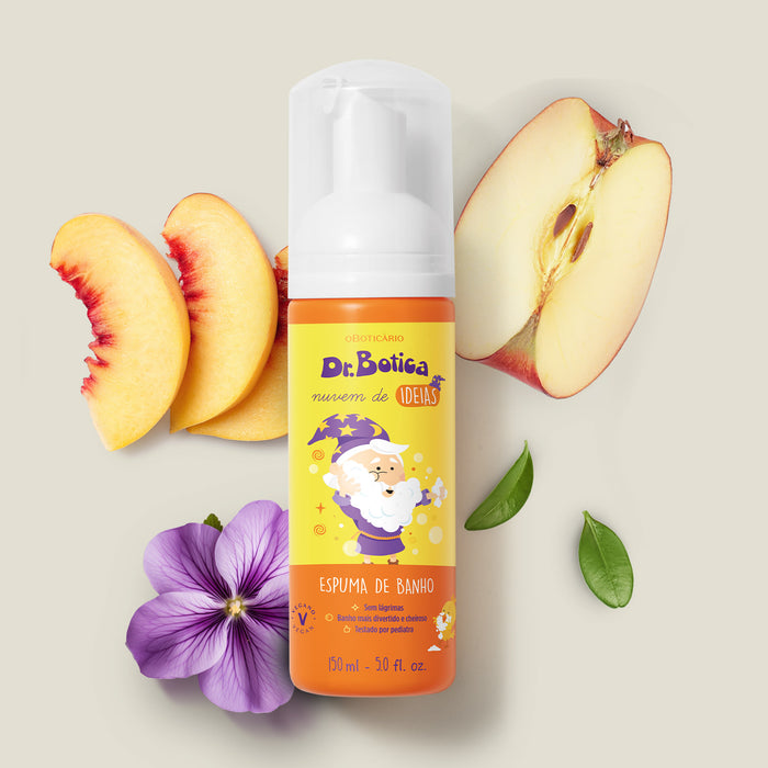 Boticario Dr. Botica Nuvem de Ideias Kids Bath Foam bottle styled with peach slices, apple and a violet flower illustrating its fruity aromatic fragrance – Buy now at MKPBR.COM – Worldwide Shipping