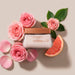 Flat lay of Boticário Elysée Satin Body Cream 250 g jar surrounded by pink roses and grapefruit illustrating the signature floral Elysée fragrance – Buy now at MKPBR.COM – Worldwide Shipping