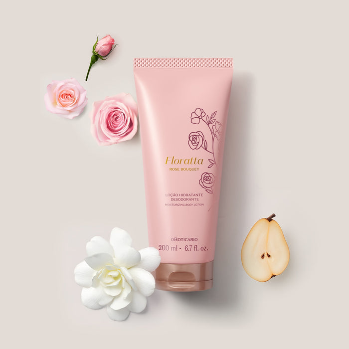 Floratta Rose Bouquet body lotion tube by O Boticário in a flat lay with pink roses, a white gardenia and a sliced pear illustrating the floral fragrance notes – Buy now at MKPBR.COM – Worldwide Shipping
