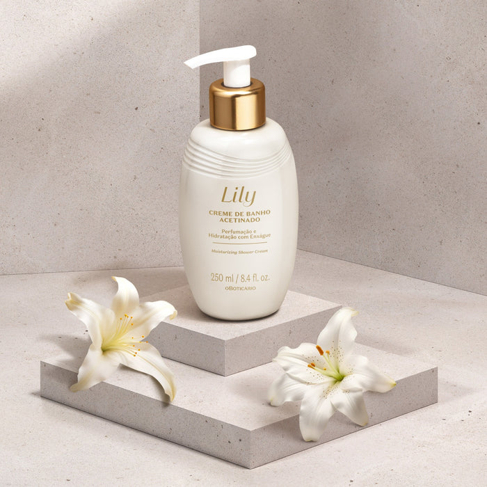 Boticário Lily Satin Shower Cream 250 ml bottle styled on a stone podium beside fresh white lily flowers – Buy now at MKPBR.COM – Worldwide Shipping