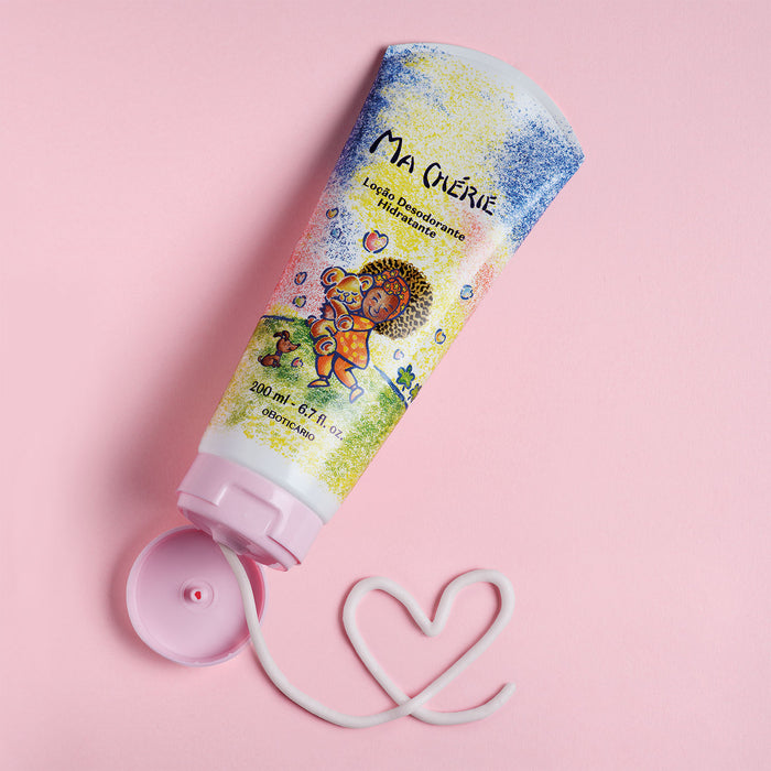 Open tube of Boticário Ma Chérie Deodorant Body Lotion with a heart drawn in white lotion on a pink background showing the creamy texture – Buy now at MKPBR.COM – Worldwide Shipping