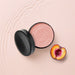 Open jar of Boticario Nativa SPA Ameixa oil-in-cream revealing the rich pink body cream next to a fresh plum – Buy now at MKPBR.COM – Worldwide Shipping