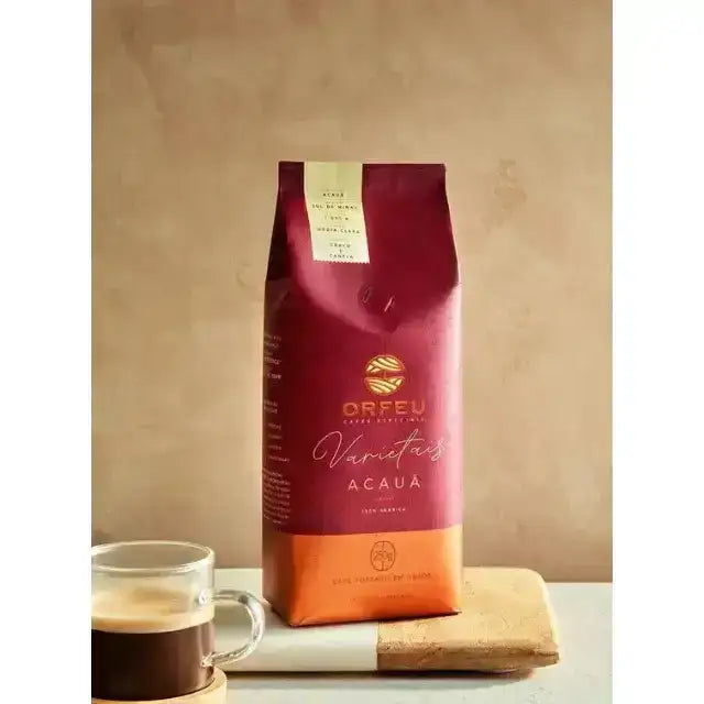 Orfeu Acauã Whole Bean Coffee –  A freshly brewed cup of Acauã coffee with the whole bean bag in the background, suggesting quality from bean to cup. – Buy now at MKPBR.COM – Worldwide Shipping