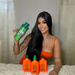 Smiling model with long hair holding Everk Preto Power 500ml and Gold Spell Receitinha Poderosa shampoo and tonic set - Buy now at MKPBR.COM - Worldwide Shipping