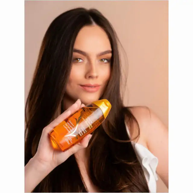 Muriel Almond & Vanilla Body Oil | Hydrating & Sensual Skin Elixir | 5.07 fl oz (150ml) - Young woman with long hair holding an Almond & Vanilla oil bottle, representing a sensual lifestyle – Buy now at MKPBR.COM – Worldwide Shipping