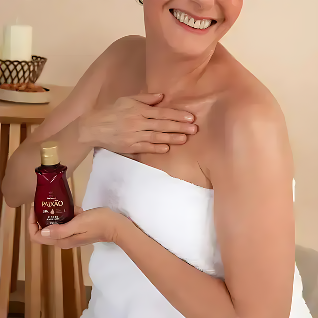 Woman applying Paixão Flor de Baunilha body oil on shoulder