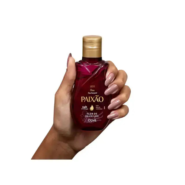 Paixão Flor de Baunilha body oil 100 mL held in hand, size reference, magenta bottle with gold cap. Buy now at MKPBR.COM – Worldwide Shipping
