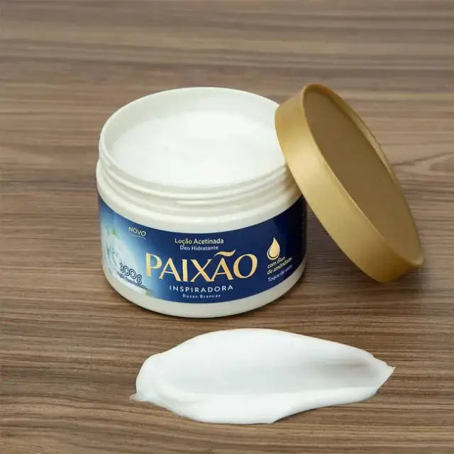 Open jar of Paixão Inspiradora Rosas Brancas body cream with a white cream swatch on a wooden surface — Buy now at MKPBR.COM – Worldwide Shipping