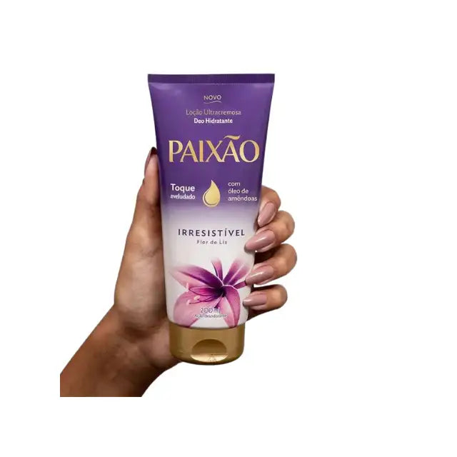 Hand holding Paixão Irresistível Flor de Lis ultra‑creamy body lotion, 200 ml purple tube on white background. Buy now at MKPBR.COM – Worldwide Shipping