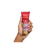 A hand with light pink manicured nails holds up a tube of Paixão Tentadora Ruby Plum hand cream against a clean white background, showcasing the product packaging and branding details – Buy now at MKPBR.COM – Worldwide Shipping