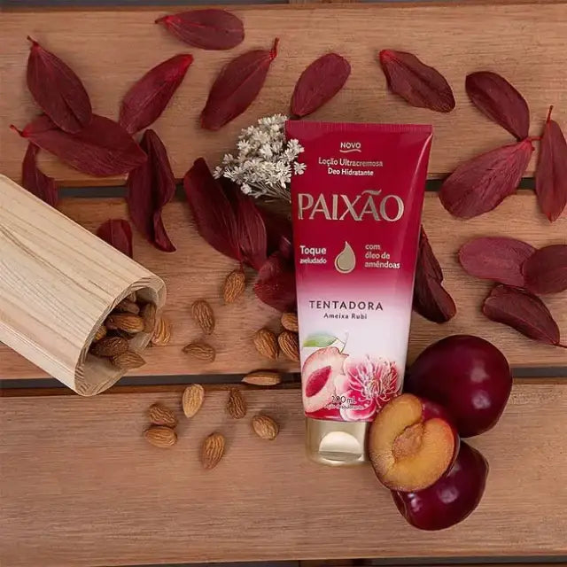 Tube of Paixão Tentadora body lotion styled with ruby plums and almonds to reflect fragrance and nourishing oils. Buy now at MKPBR.COM – Worldwide Shipping