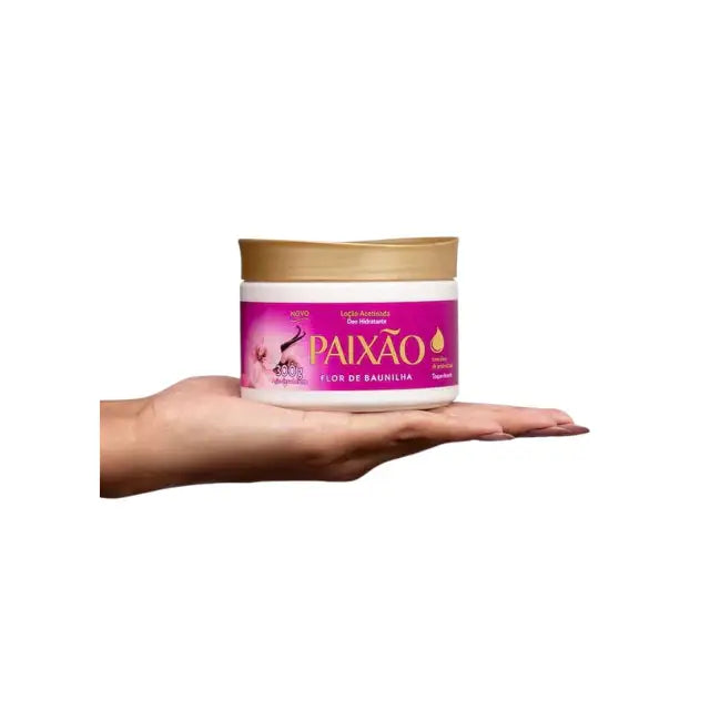 Hand holding Paixão Flor de Baunilha 300g body lotion jar, showing size and easy grip, new packaging with vanilla flower and almond oil benefits. Buy now at MKPBR.COM – Worldwide Shipping