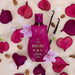 Flat lay of Paixao Vanilla Flower lotion 200 ml with vanilla pods, almonds, orchid flowers, and pink heart petals. Buy now at MKPBR.COM – Worldwide Shipping