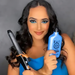 Woman styling with curling iron holding Receitinha Obrigatoria By Gold Spell Co hair cream – Buy now at MKPBR.COM – Worldwide Shipping