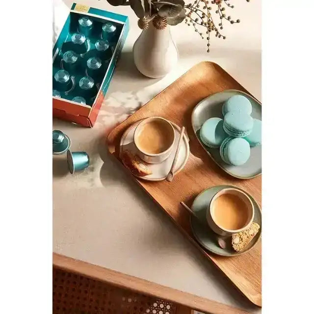 Orfeu Arara Nespresso Compatible Coffee Capsules - A lifestyle flat lay featuring the Orfeu Arara capsule box, a brewed cup, and sweet treats, creating an inviting scene. – Buy now at MKPBR.COM – Worldwide Shipping