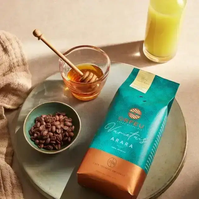 Orfeu Arara Whole Bean Coffee – A lifestyle flat lay featuring the Orfeu Arara Whole Bean Coffee package, a coffee bean cup, and natural sweeteners, creating an inviting scene. – Buy now at MKPBR.COM – Worldwide Shipping